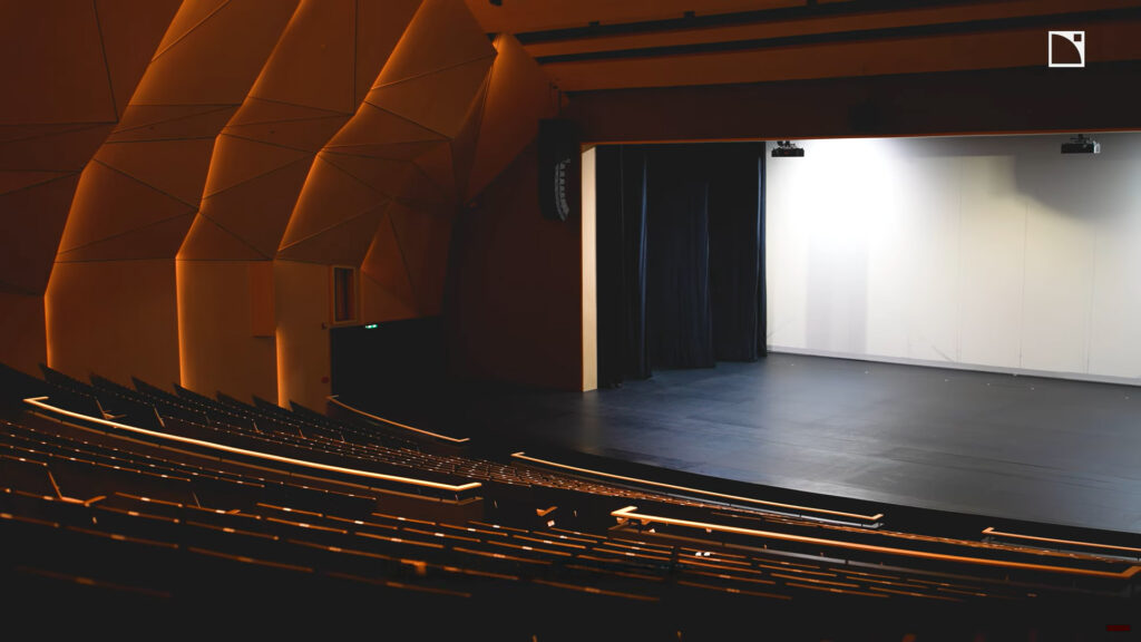 Horizon view of the ISB Theater stage featuring some of the speakers in their professional sound system.